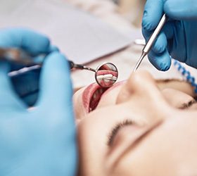 Dentist inspecting a patient’s teeth