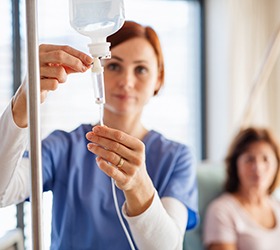 Woman setting up an IV drip